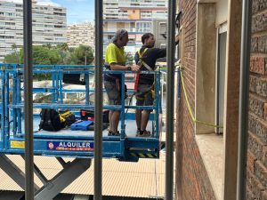Instaladores de Akraclima realizando trabajos verticales para la instalación de un aparato de aire acondicionado por conductos en una fachada